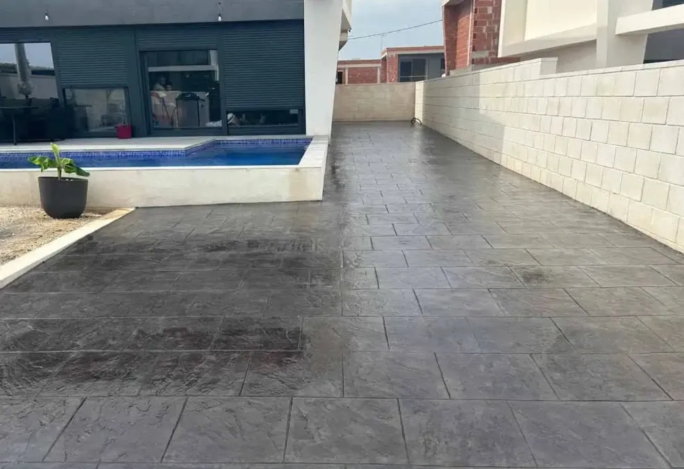 Patio de losa antracita junto a una piscina