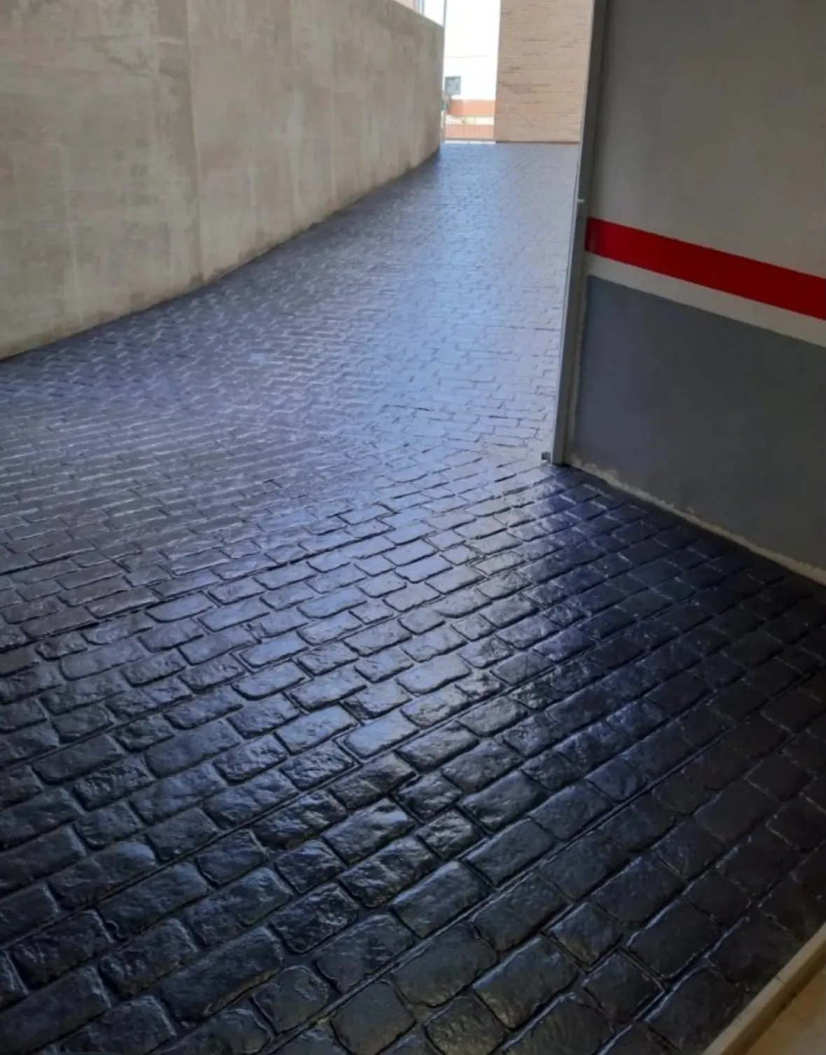 Rampa de garaje de hormigón impreso con molde de adoquín antracita